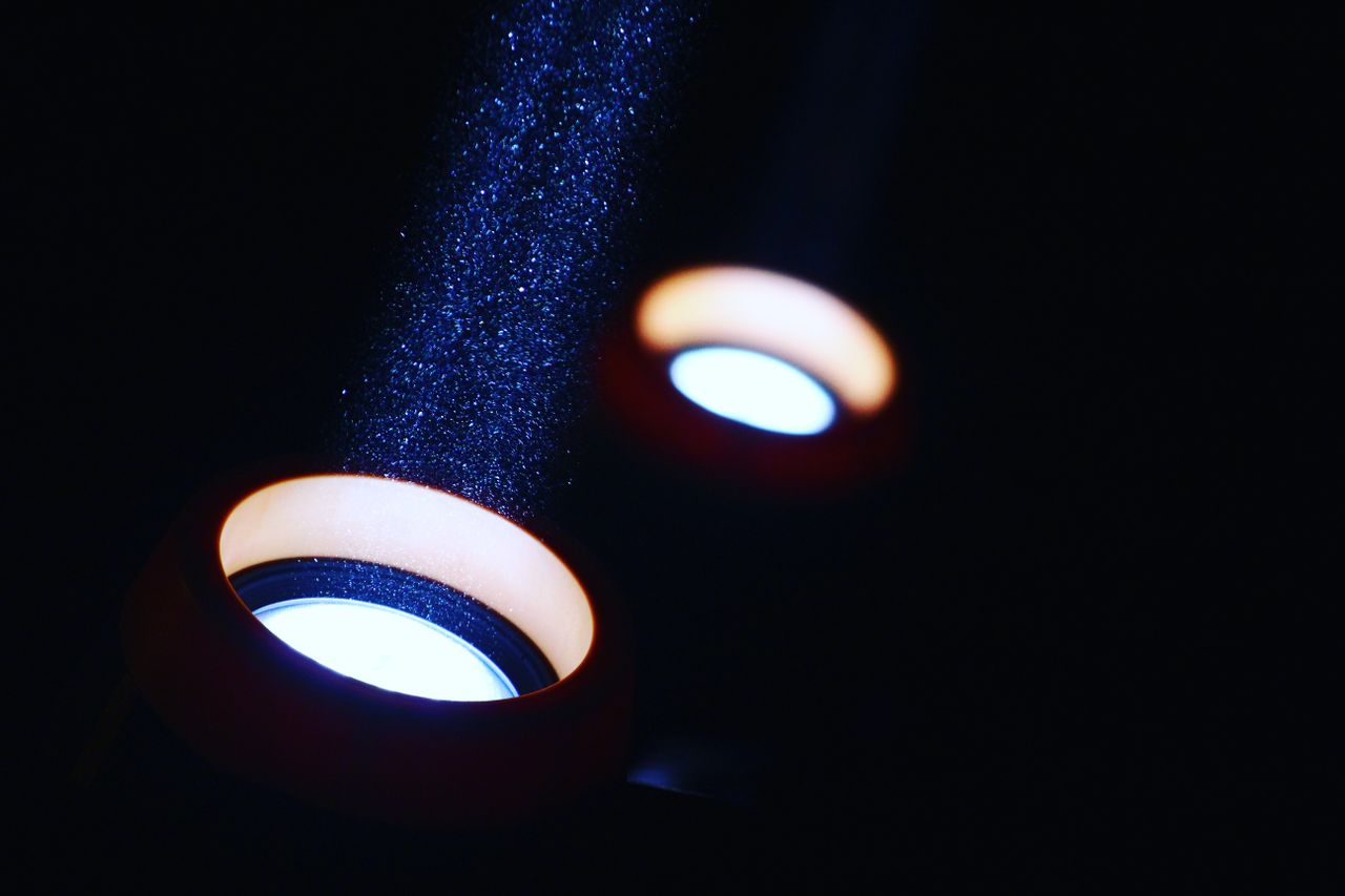 A striking visual of light beams illuminating particles in a dark setting, creating an abstract effect.